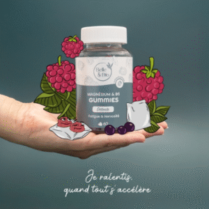 Posé sur une main de femme, le flacon de gummies est entouré de framboises.